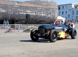One of the older cars driving the circuit in front of a submarine